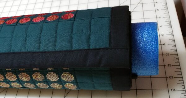 Quilt rolled up on a swimming pool noodle