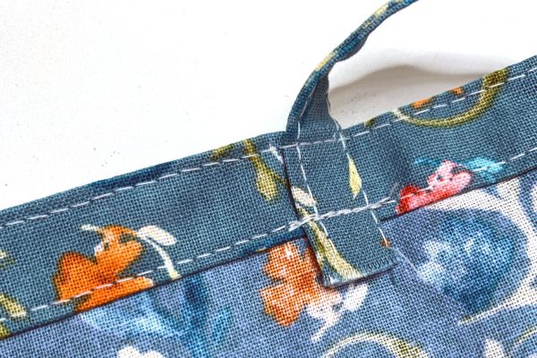 Edge stitch along upper edge of casing catching in all four straps