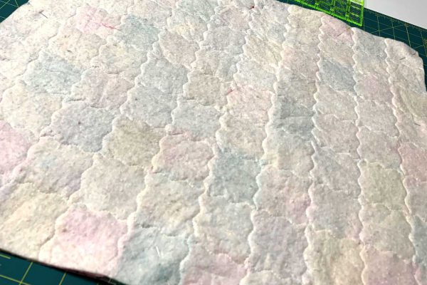 The backside of the patchwork quilt for 18 inch doll with stipple stitch