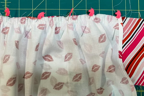Adjust gathers to fit waistband on apron