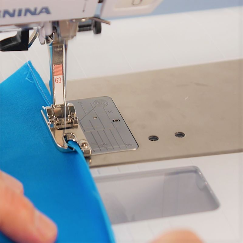 WAS_3_Ways_to_Hem_03_holding_fabric_in_front_of_foot_BERNINA_WeAllSew_Blog_800x800px
