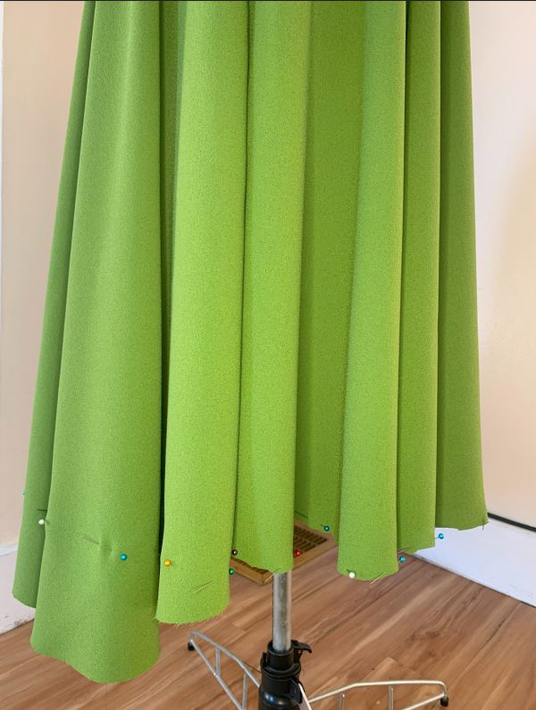 A skirt hem that is partially trimmed. One side is even and the other is not.