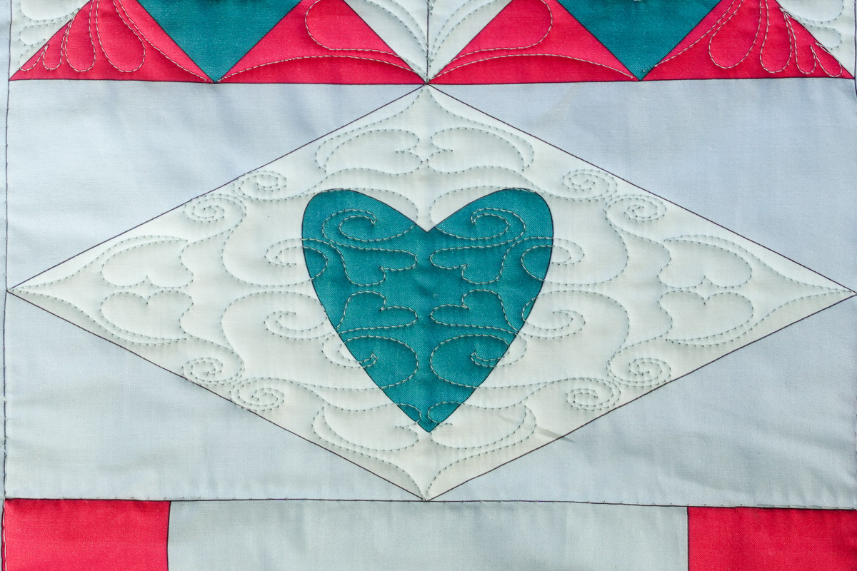 Closeup of the Heart Block 1 design quilted over the Diamond Heart Block on the Jump for Joy quilt.