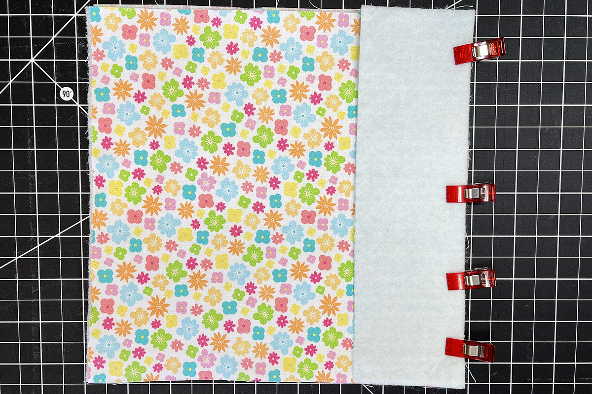 overhead view of floral fabric clipped to a rectangle piece of fabric.