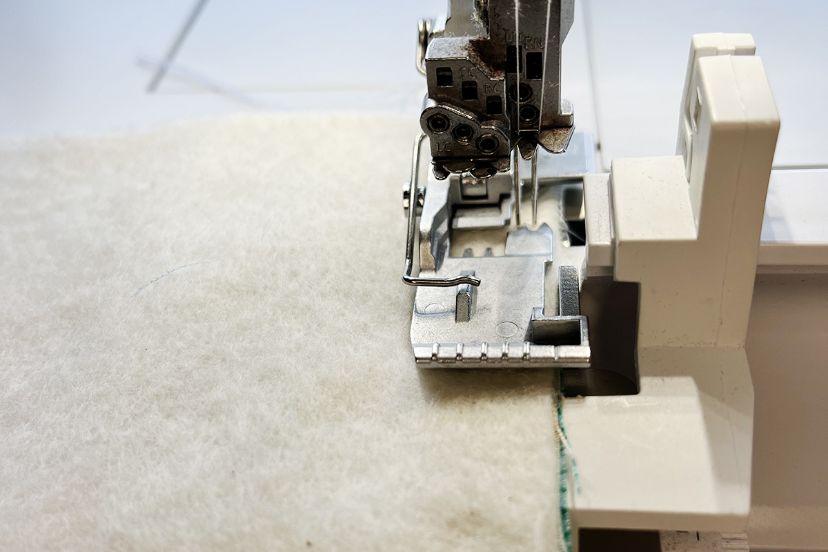 front view of fabric being fed through serger under the presser foot.