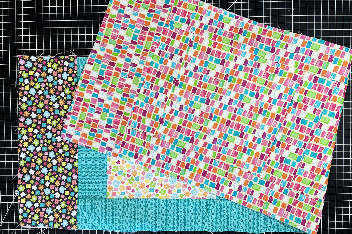 overhead view of multi-color fabric squares and borders sewn together.