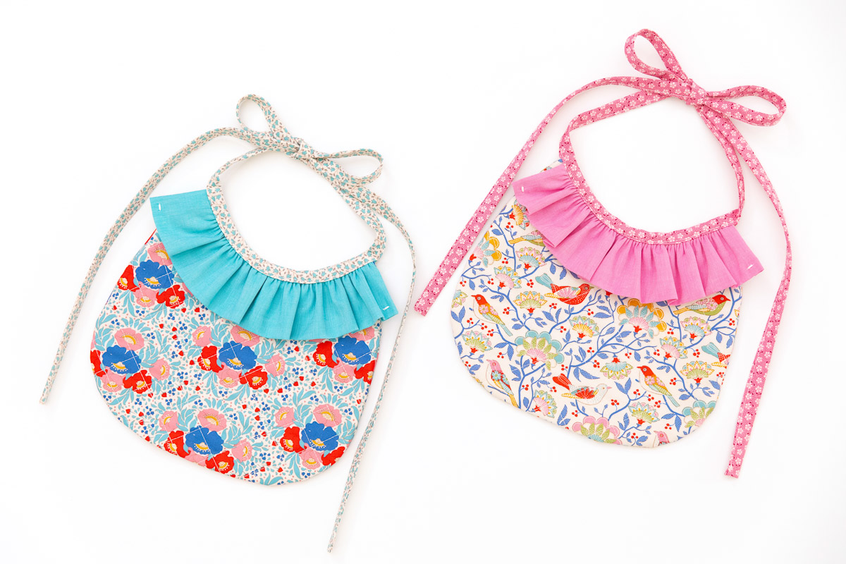 Two bibs against white background