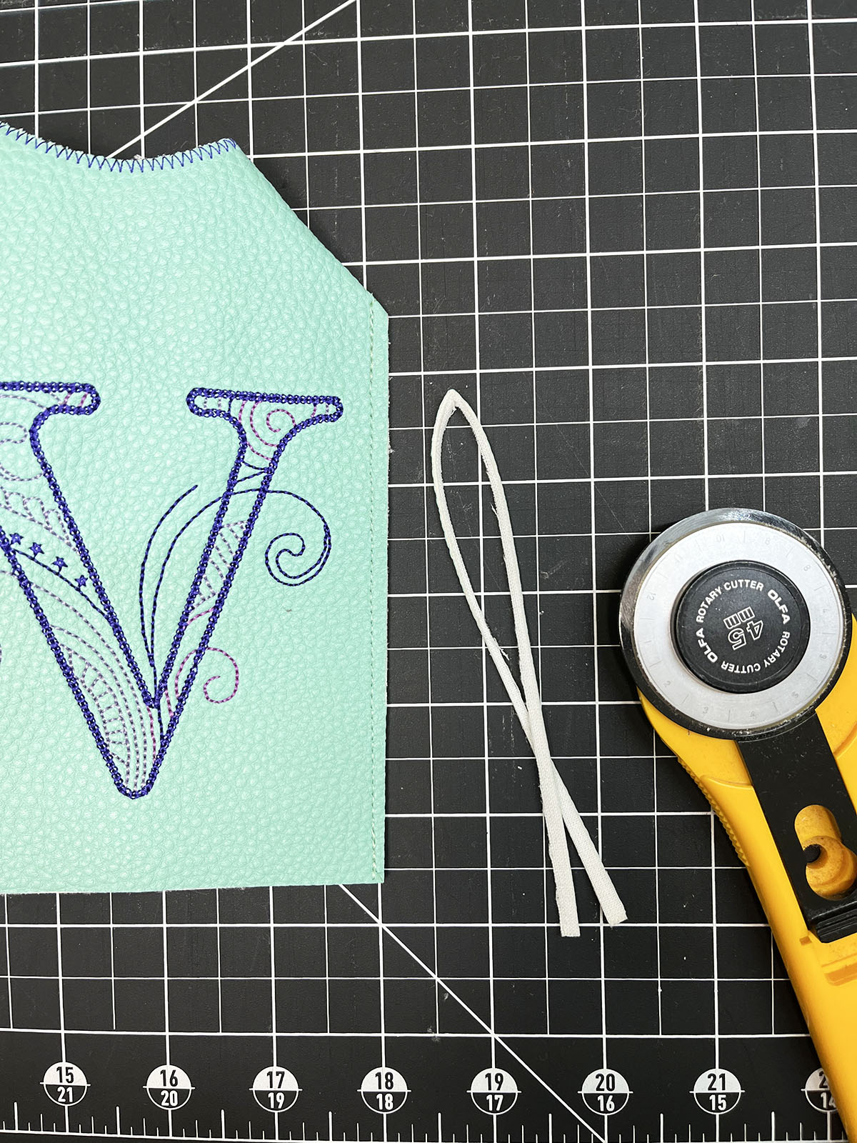 Embroidered vinyl and other materials on black cutting mat