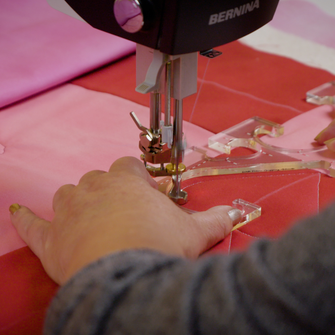 Up-close view of ruler flipped to other side on red and pink checkered quilt