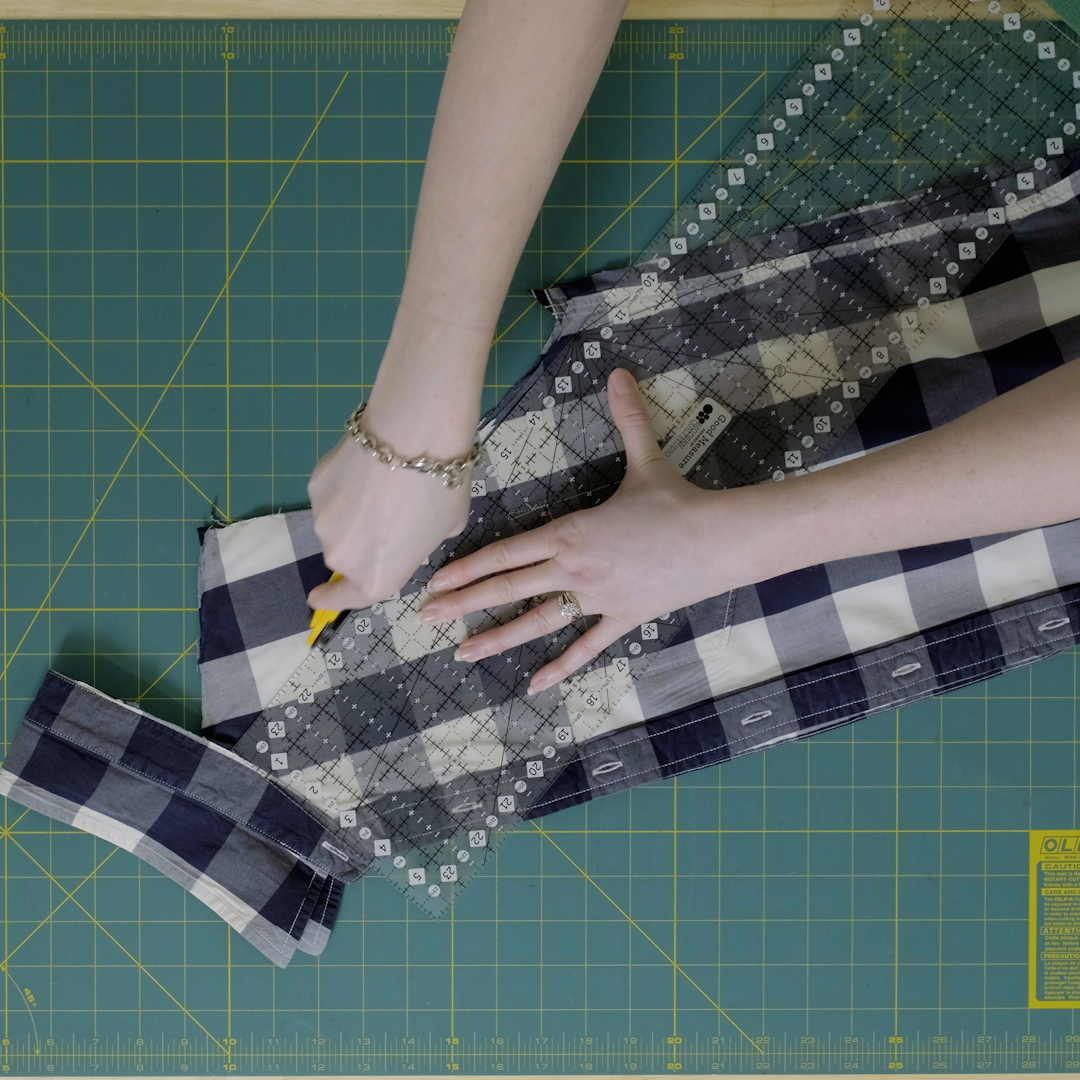 Rotary cutter and ruler used to cut folded shirt