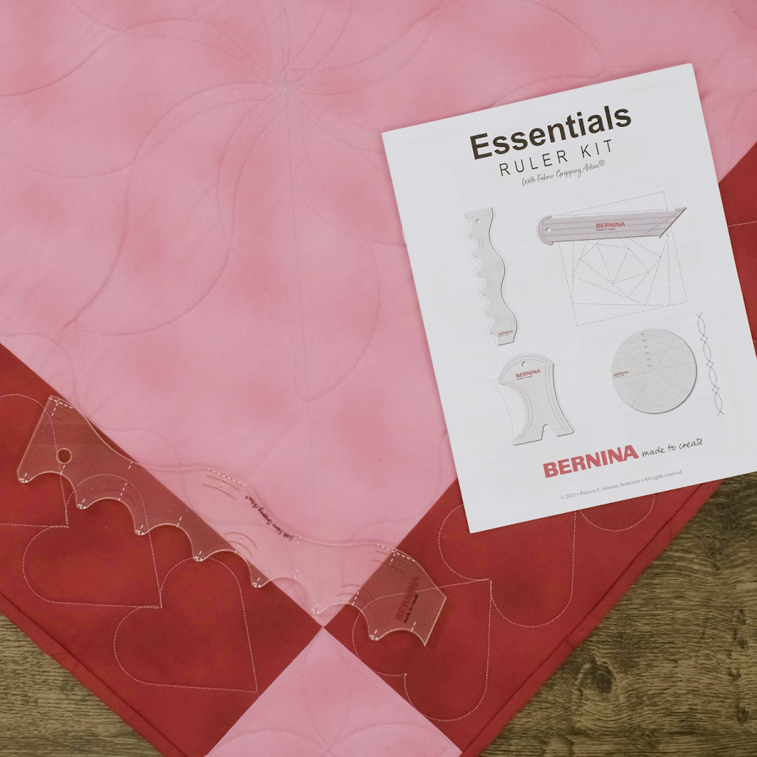 Overhead view of essentials ruler kit instructional manual over red and pink checkered table topper