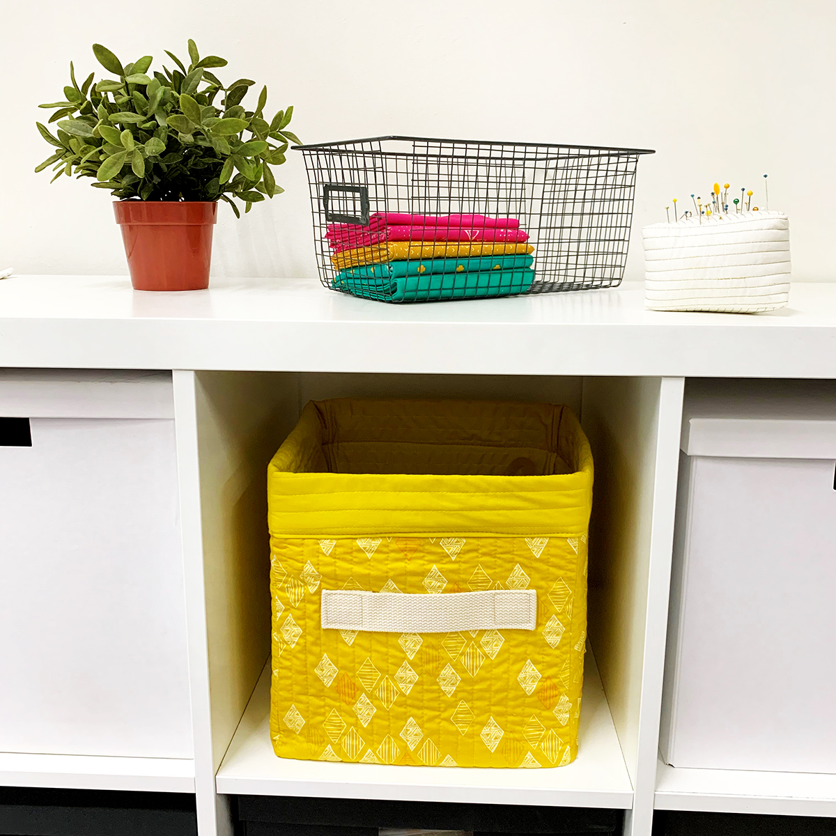 Yellow storage bin on shelf with various surrounding items
