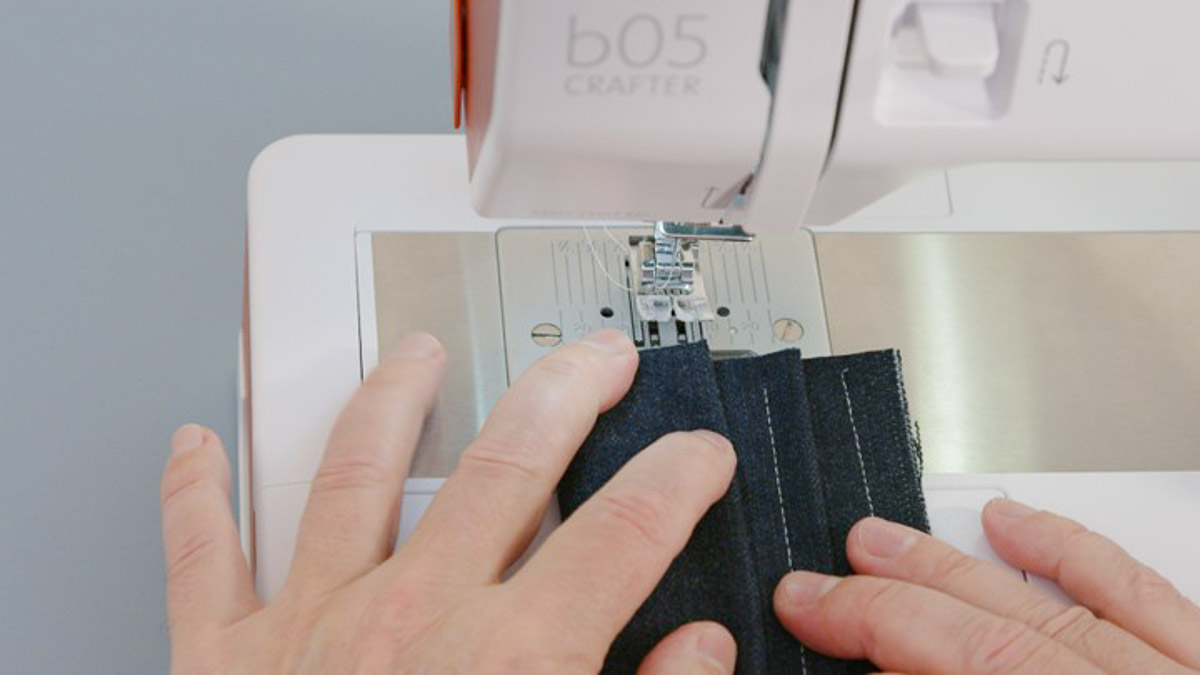Overhead view of denim fabric being sewn in layers