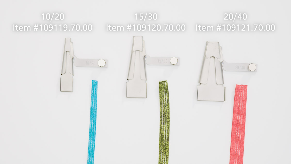 blue, green, and coral fabric in varying widths with three different Belt Loop Folders in three different sizes