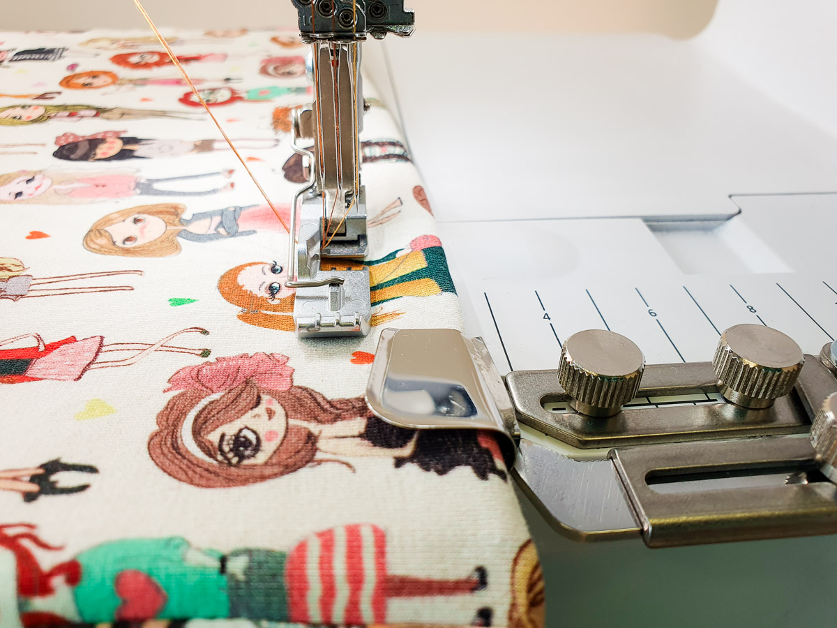 stitching white fabric covered in artistic female renderings