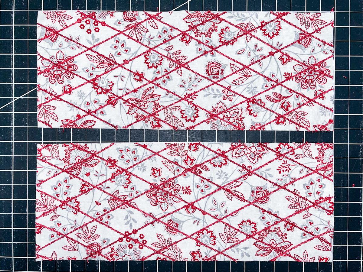 Overhead view of colorful fabric quilted with red thread