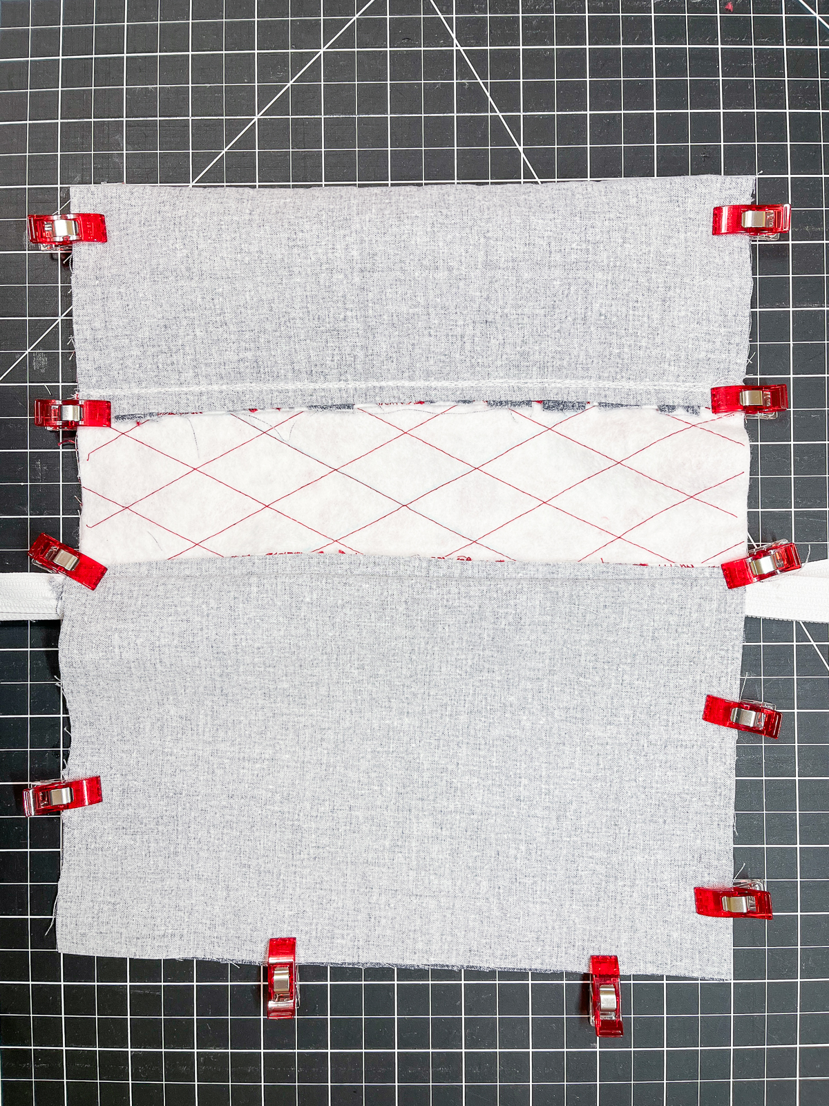 Wrong sides of a sewn pouch in progress, held together with Wonder Clips