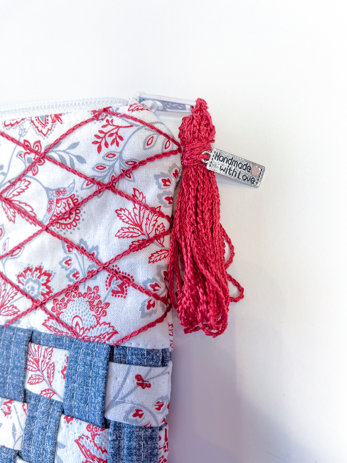 Finished view of the woven zipper pouch adorned with a red tassle