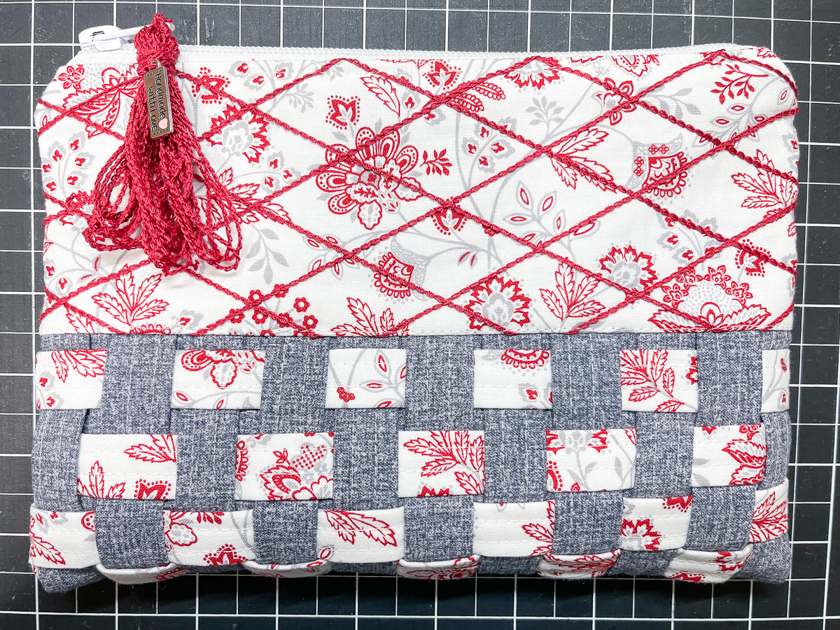 Finished view of the woven zipper pouch adorned with a red tassle