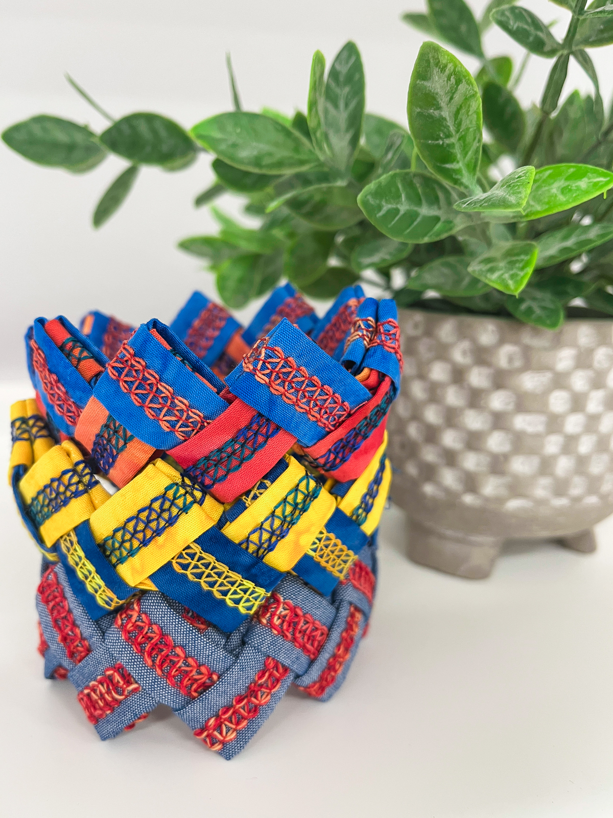 Bracelets in various colors displayed in front of plant pot.
