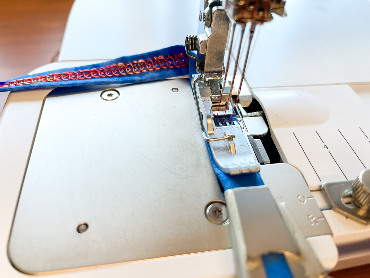 Sewing red thread onto blue fabric