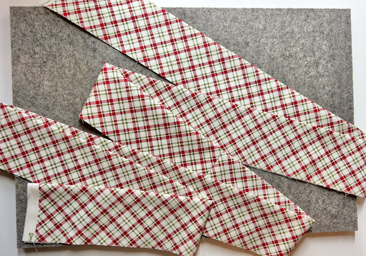 pressed red plaid fabric strips on a grey background.