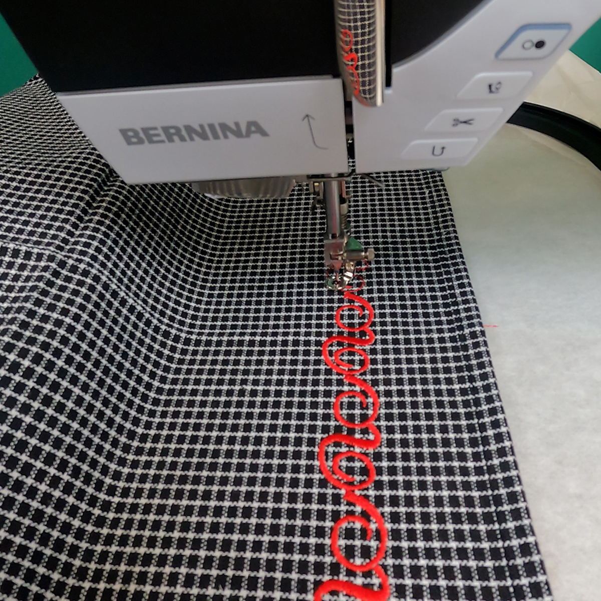 close-up view of red embroidery design on a black and white checked tea towel