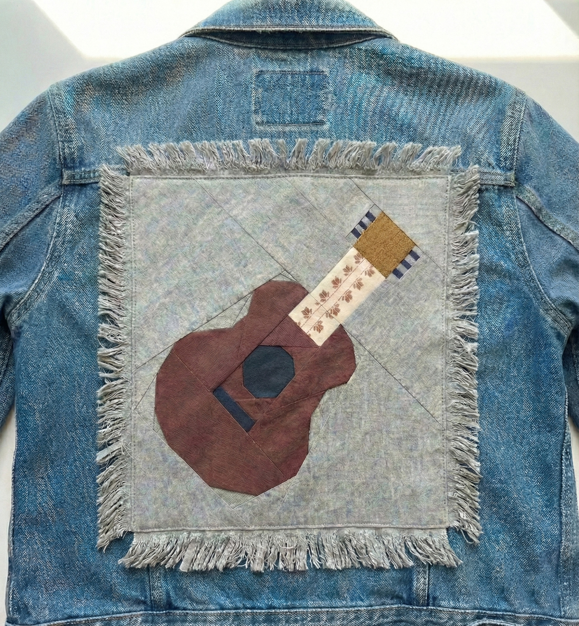 Guitar quilt block pattern on the back of a Jean Jacket