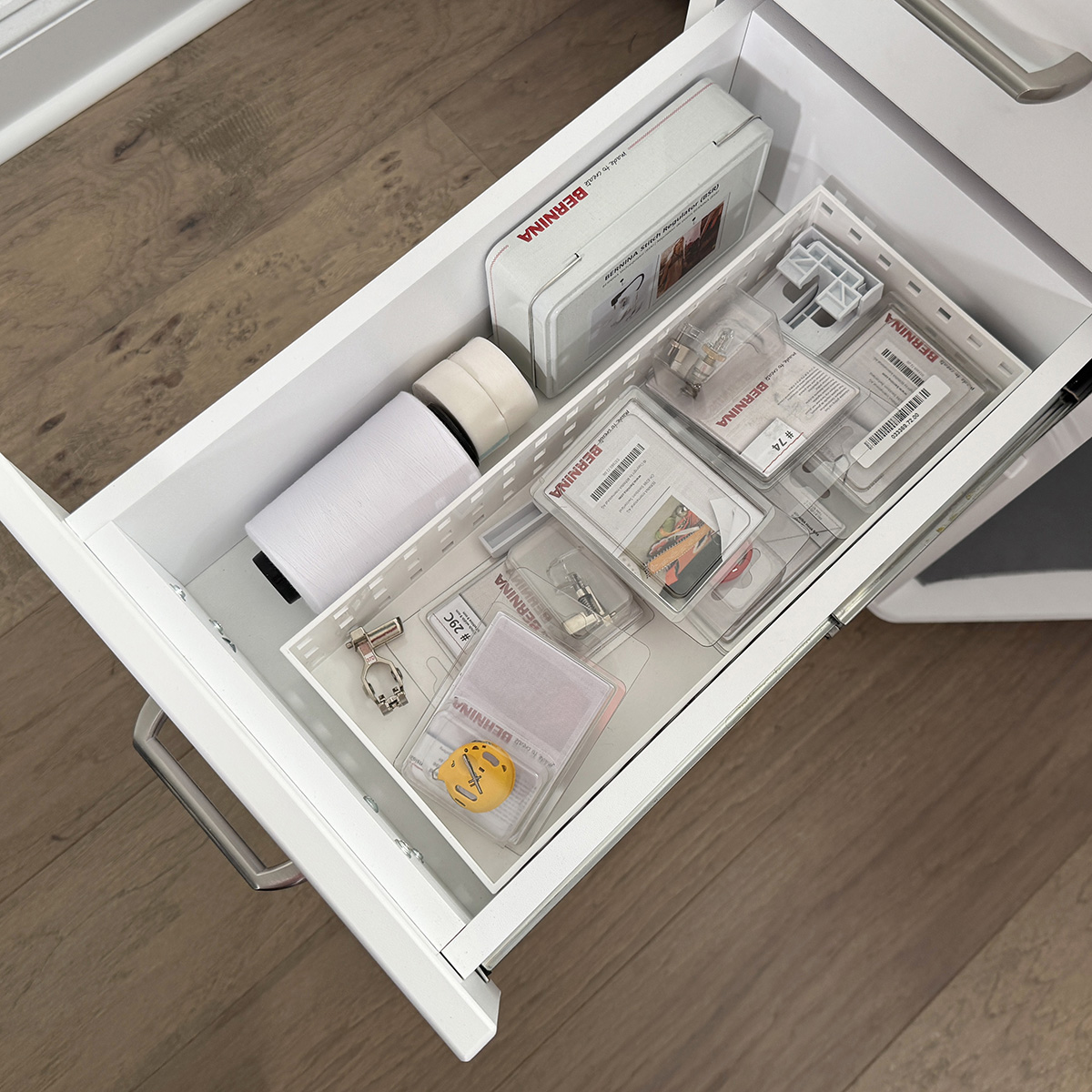 The second drawer holds mostly embroidery supplies.  Things like OESD bobbin thread and tear-away tape, the high tension bobbin case, plus some extra feet that don't fit in my Barbie box, which I keep on top of the cabinet.