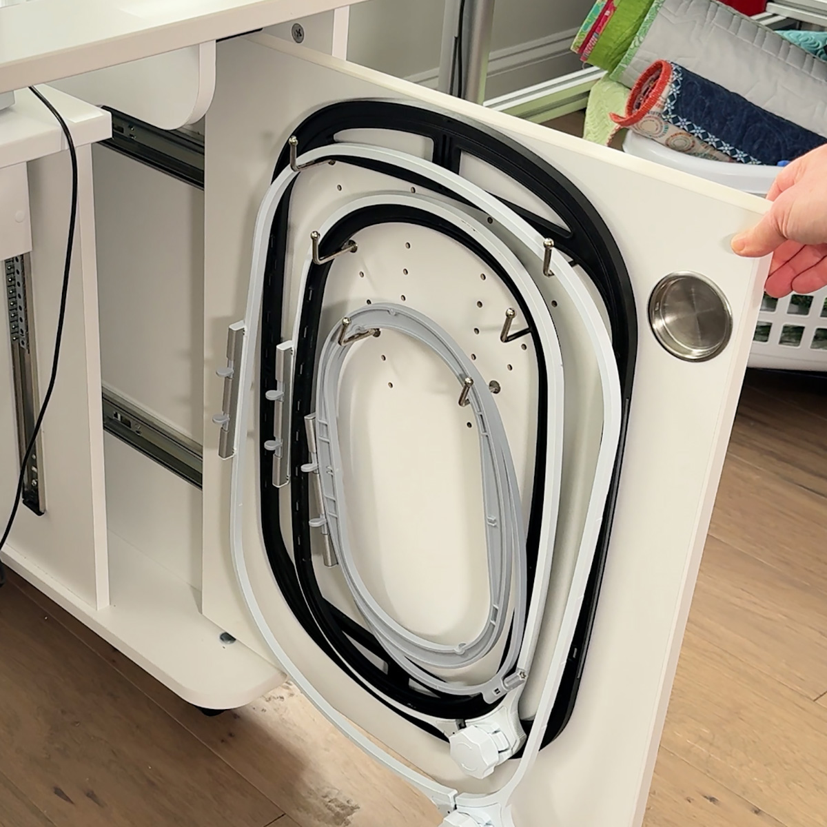 Under the right side of the cabinet, there is an area to store hoops - even the Giant Hoop fits!