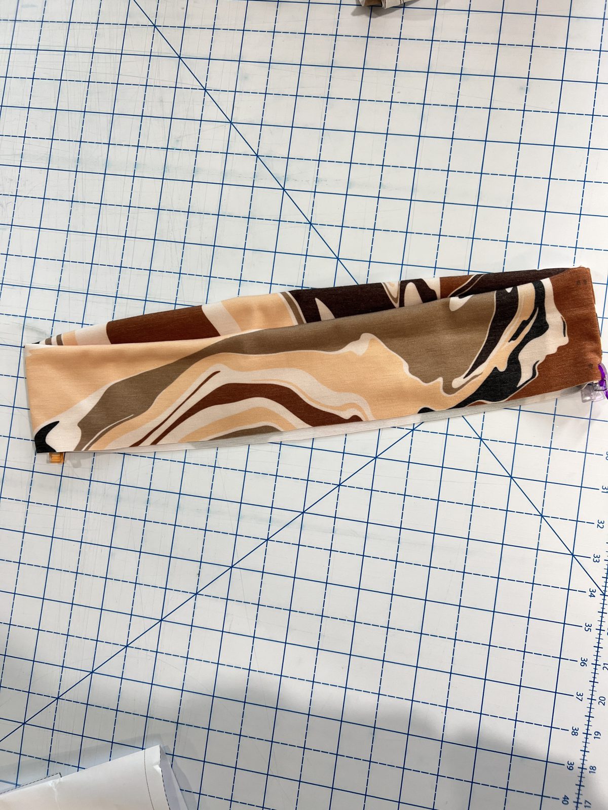 With wrong sides together, fold pants waist band in half long ways